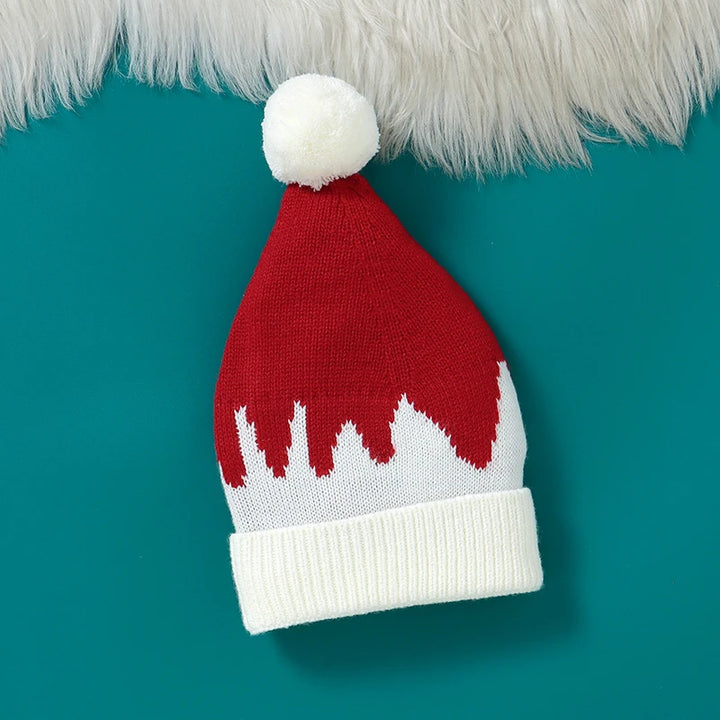 Bonnet de Noël rouge et blanc avec pompon pour enfants sur fond turquoise.
